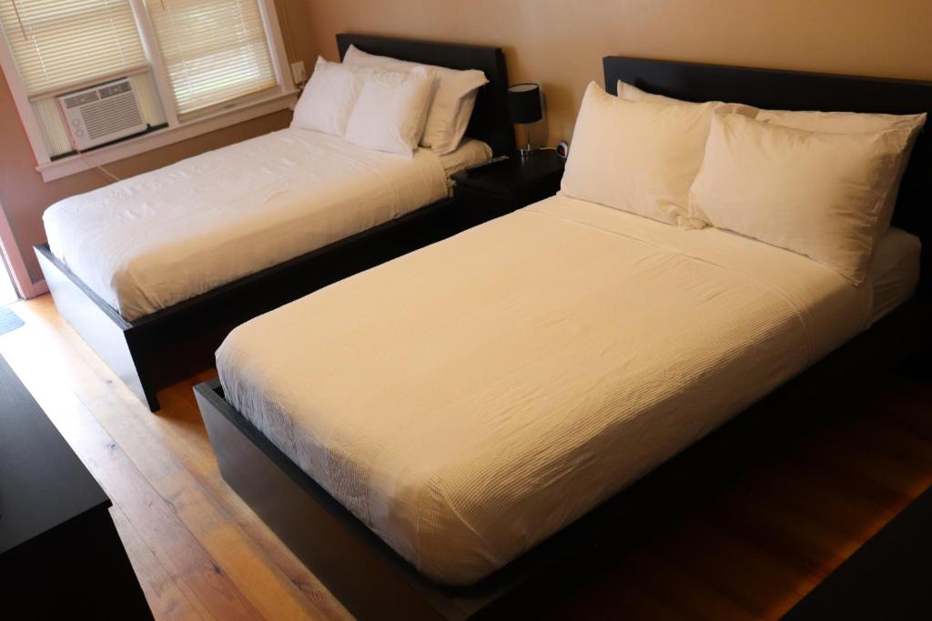 two beds in a hotel room with white sheets at Reynolds House inn in Roscoe