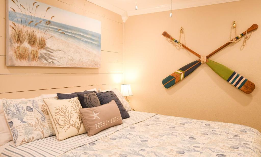 een slaapkamer met een bed met kussens en een schilderij bij New Listing! Beautiful 1/1 Condo with Gorgeous Beach Views! Pool & Hot Tub!! - Shell We Dance in Galveston