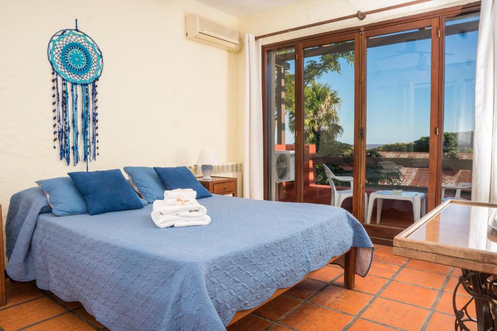 sypialnia z niebieskim łóżkiem i ręcznikami w obiekcie Viajero Posada B&B w mieście Colonia del Sacramento