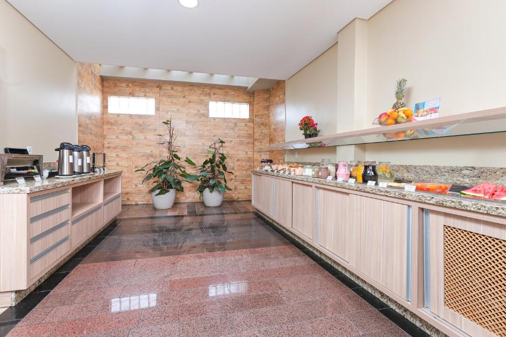 a large kitchen with counter tops and plants at Hotel Express Terminal Tur - Rodoviária Porto Alegre in Porto Alegre