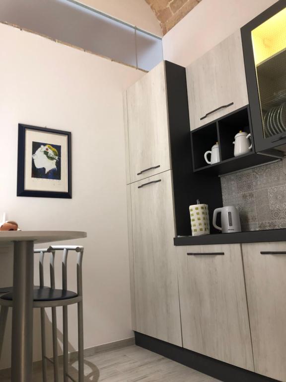 kuchnia z białymi szafkami i stołem w obiekcie B & B Via Cavour w mieście Termoli