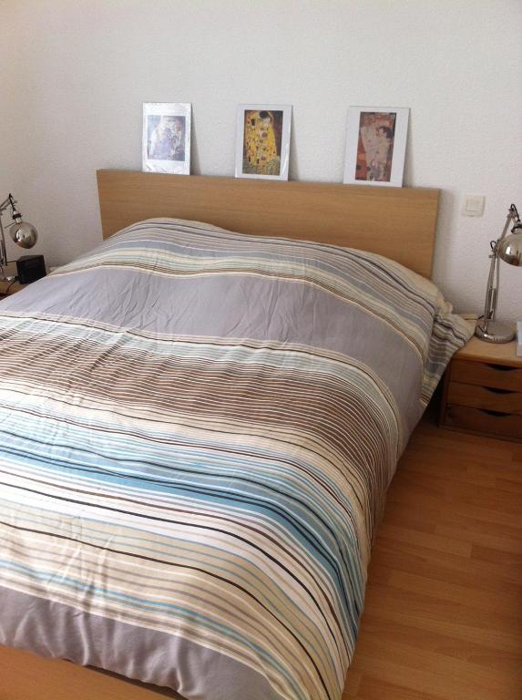 - un lit avec une couverture rayée dans une chambre dans l'établissement T3 3 étoiles hyper centre Luchon, à Luchon