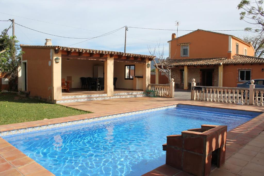 a swimming pool in front of a house at Villa Almendros - Deniasol in Denia