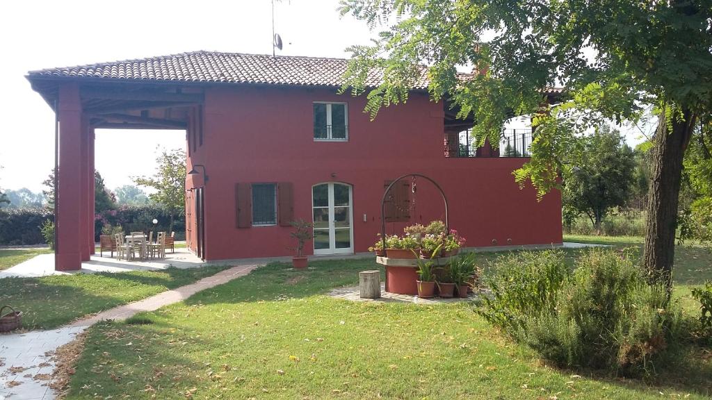 ein rotes Haus mit einem Tor im Hof in der Unterkunft SANTA MARIA DI LORGANA in Minerbio