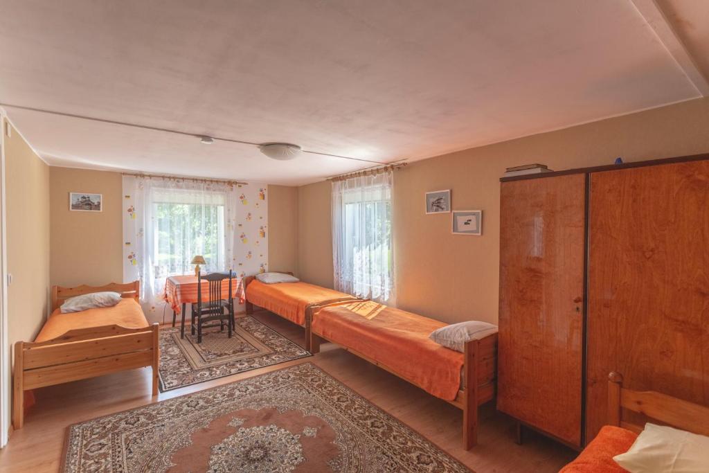 1 dormitorio con 2 camas y mesa. en Kalamehe Farmstay, en Alatskivi