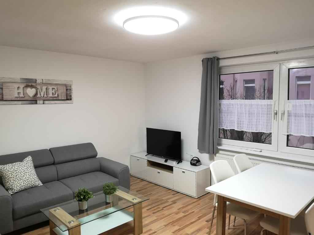 ein Wohnzimmer mit einem Sofa und einem TV in der Unterkunft Lüdenscheid-Ferienwohnung de Betzler B35-70 in Lüdenscheid