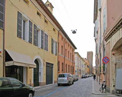 una strada cittadina con auto parcheggiate sulla strada di A Casa Di Paola Suite a Ravenna