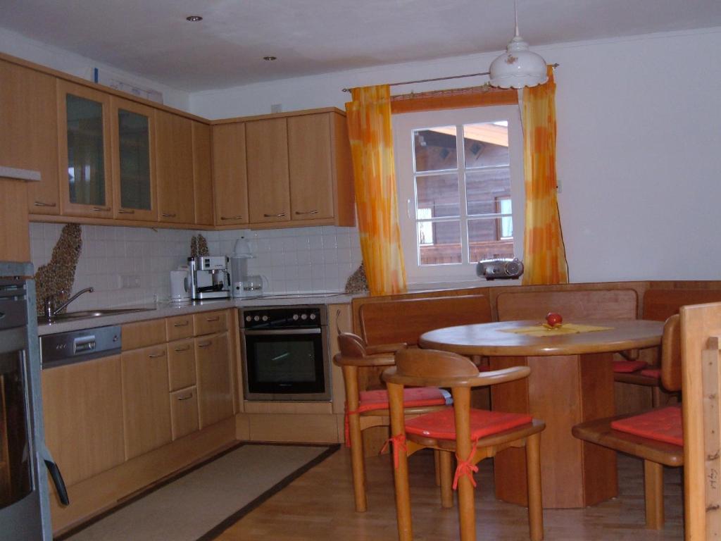 a kitchen with a table and chairs and a window at Haus Loferer in Sankt Martin bei Lofer