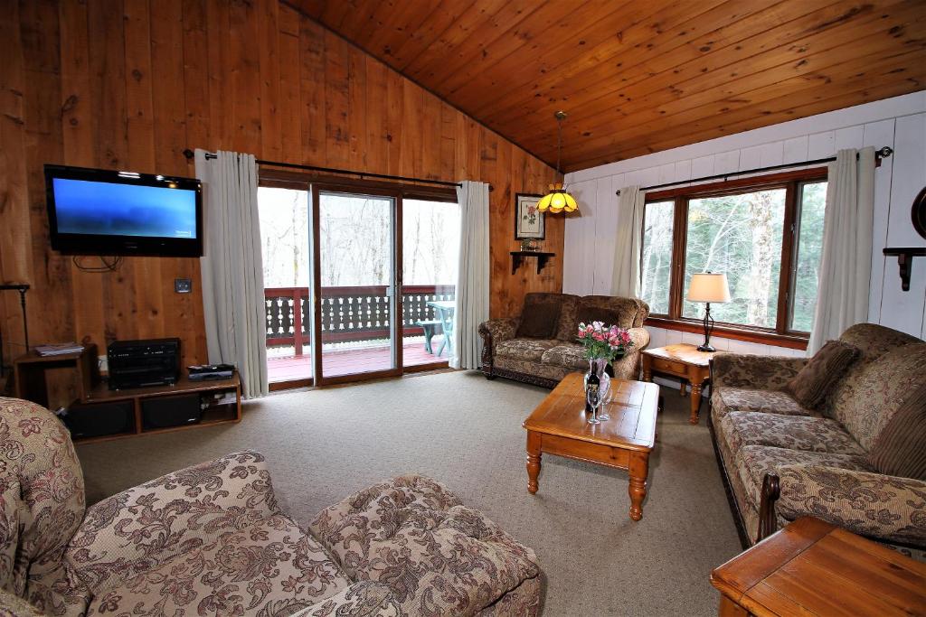 a living room with couches and a flat screen tv at Spacious Townhouse Great for large groups family Snow Flake in Killington