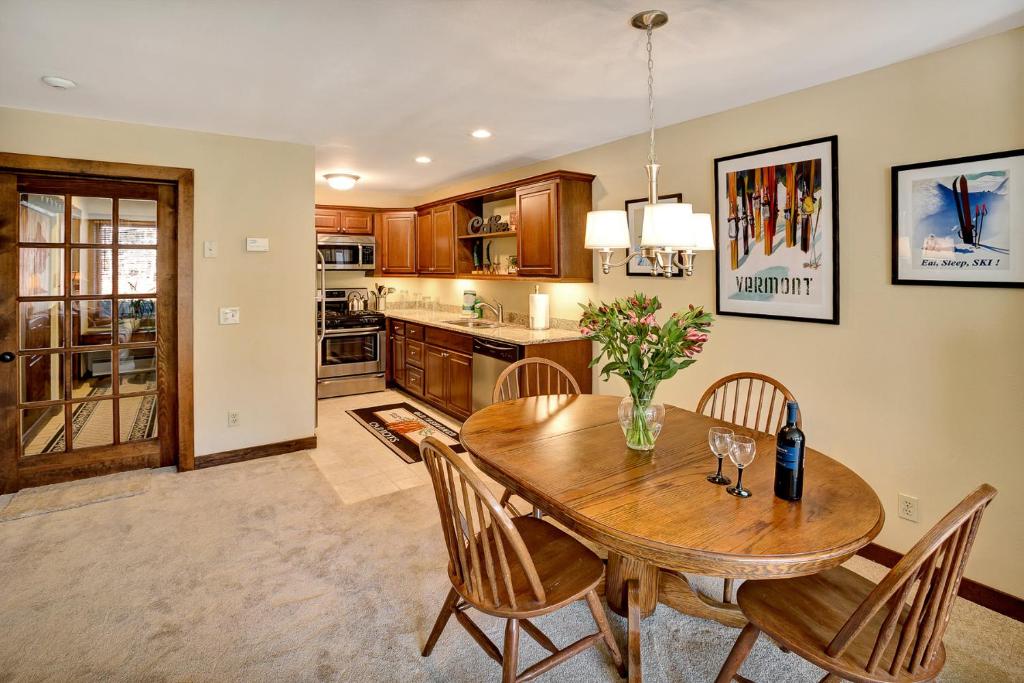a kitchen with a wooden dining room table and chairs at Ski on ski off right from your door nicely decorated 2 bedroom, Sunrise L3 in Killington