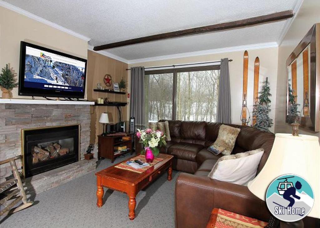 a living room with a couch and a fireplace at Beautifully decorated, 3 bedroom 2 bedroom condo is moments away from the Base Lodges Whiffletree D2 in Killington