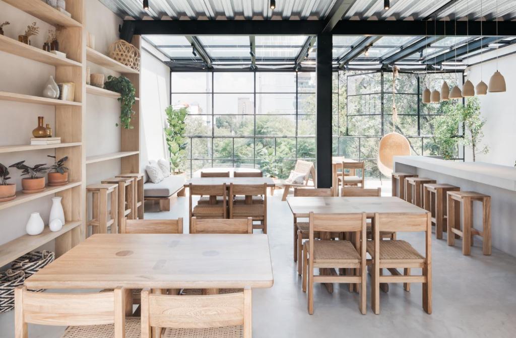 a restaurant with wooden tables and chairs and large windows at Casa Pancha in Mexico City