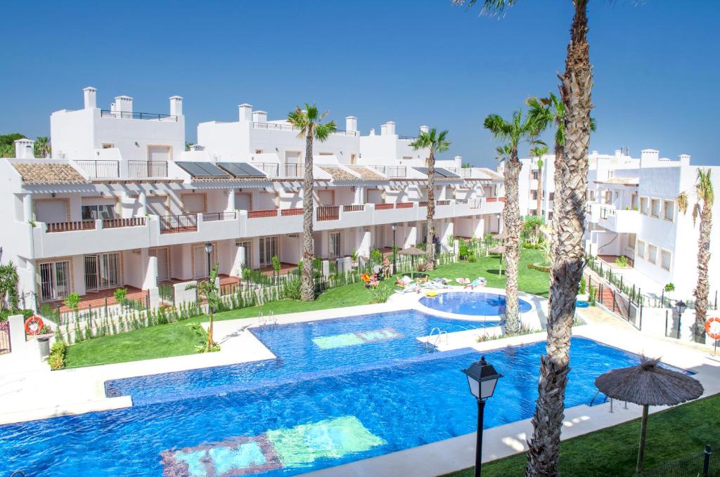 una vista aérea de un complejo con piscina y palmeras en Residencial Linnea Sol by Mar Holidays, en Playas de Orihuela