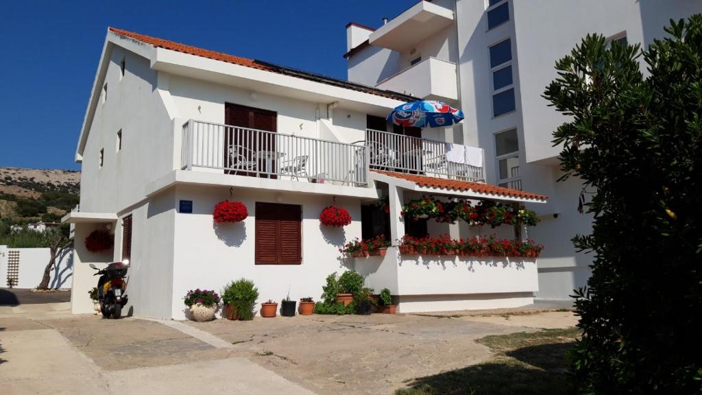 a white apartment building with flowers on the balconies at Apartments Magdalena in Pag