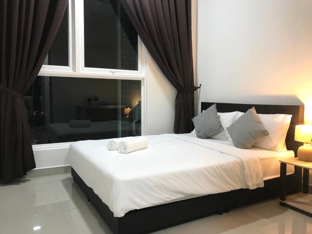 a bedroom with a large bed with a window at Fabulous Mutiara Ville Cyberjaya in Cyberjaya