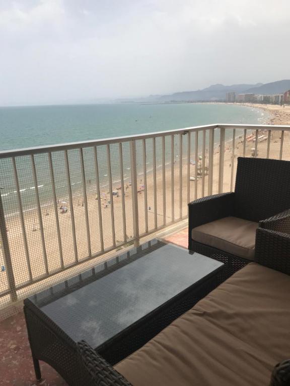 a balcony with a couch and a coffee table on the beach at Descans in Cullera