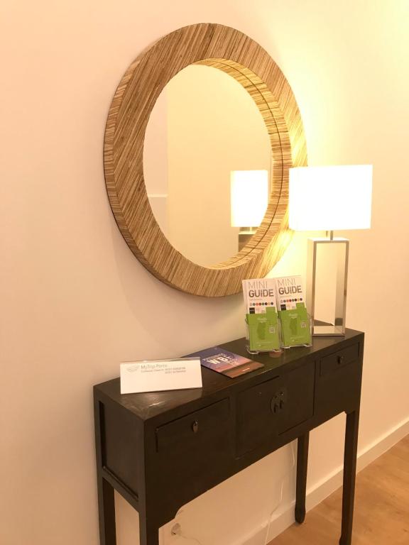 a black dresser with a mirror on a wall at MyTrip Porto in Matosinhos