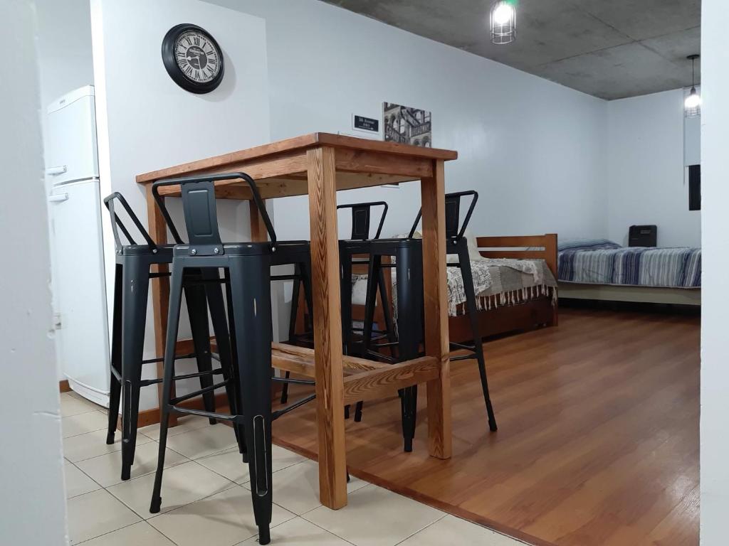 een tafel en stoelen in een kamer met een bed bij Depto calle 20 y 37 - monoambiente, muy bonito y luminoso! in La Plata