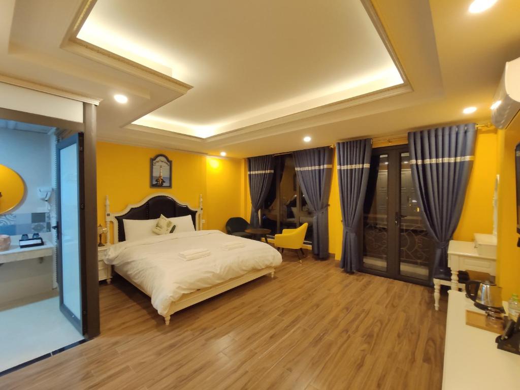 1 dormitorio con 1 cama con paredes amarillas y suelo de madera en Bonjour Sa Pa Hotel, en Sa Pa
