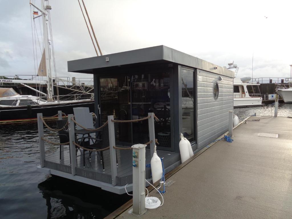 un petit bateau avec un restaurant sur l'eau dans l'établissement Hausboot Paulada-Mare, à Flensbourg