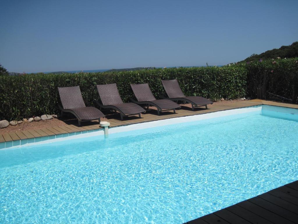 un groupe de chaises assises à côté d'une piscine dans l'établissement BENEDETU, à Porto-Vecchio