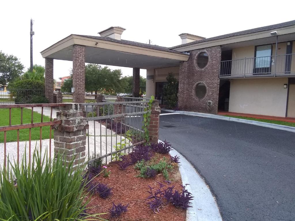 a house with a fence in front of a driveway at Gateway Inn Savannah in Savannah