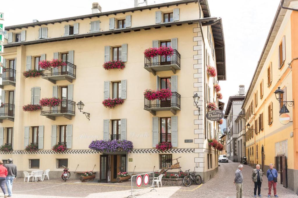 a building with flowers on the balconies on a street at Meublé Albergo Dante in Bormio