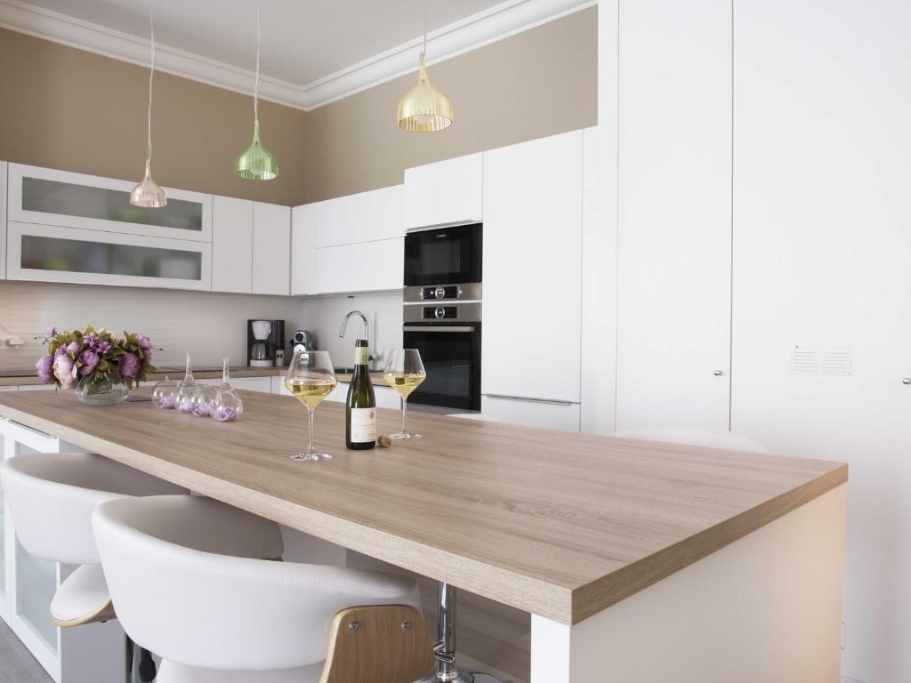 a kitchen with a wooden counter with two glasses of wine at Sasha bel appartement renove centre ville Beaune in Beaune