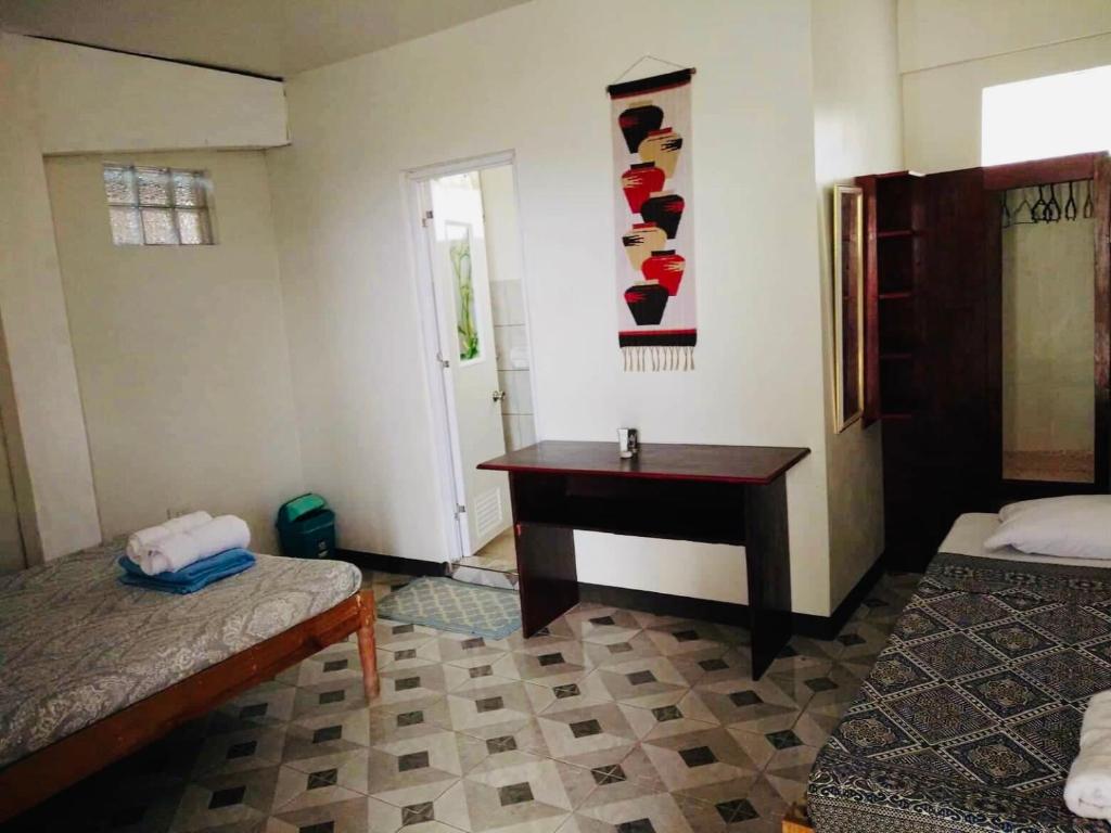 a room with two beds and a desk in it at Mayoyao View Inn in Banaue