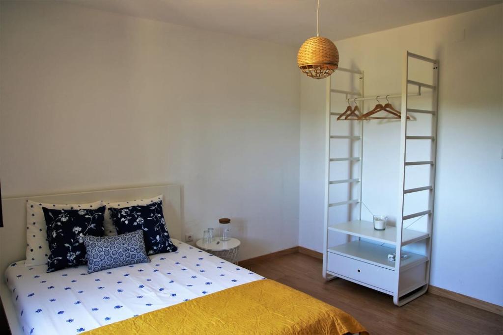 1 dormitorio con cama, escalera y estante en Quinta JR - Casa de campo, en Carregal