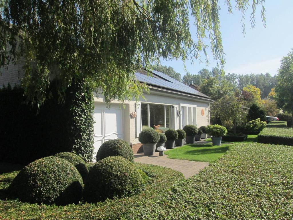 une maison avec des buissons devant elle dans l'établissement B&B Huize Van Damme, à Nieuport