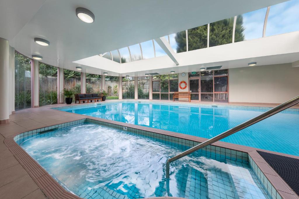 uma grande piscina interior com uma grande piscina em Kimberley Gardens Hotel, Serviced Apartments and Serviced Villas em Melbourne