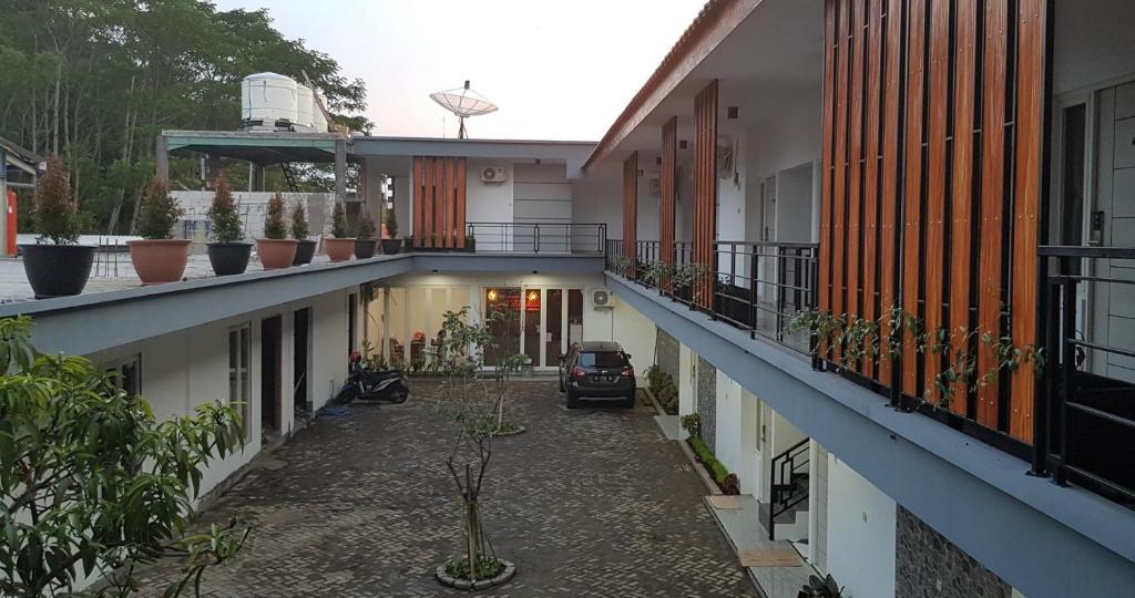 an alley between two buildings with a car in the middle at crystal inn in Pasuruan