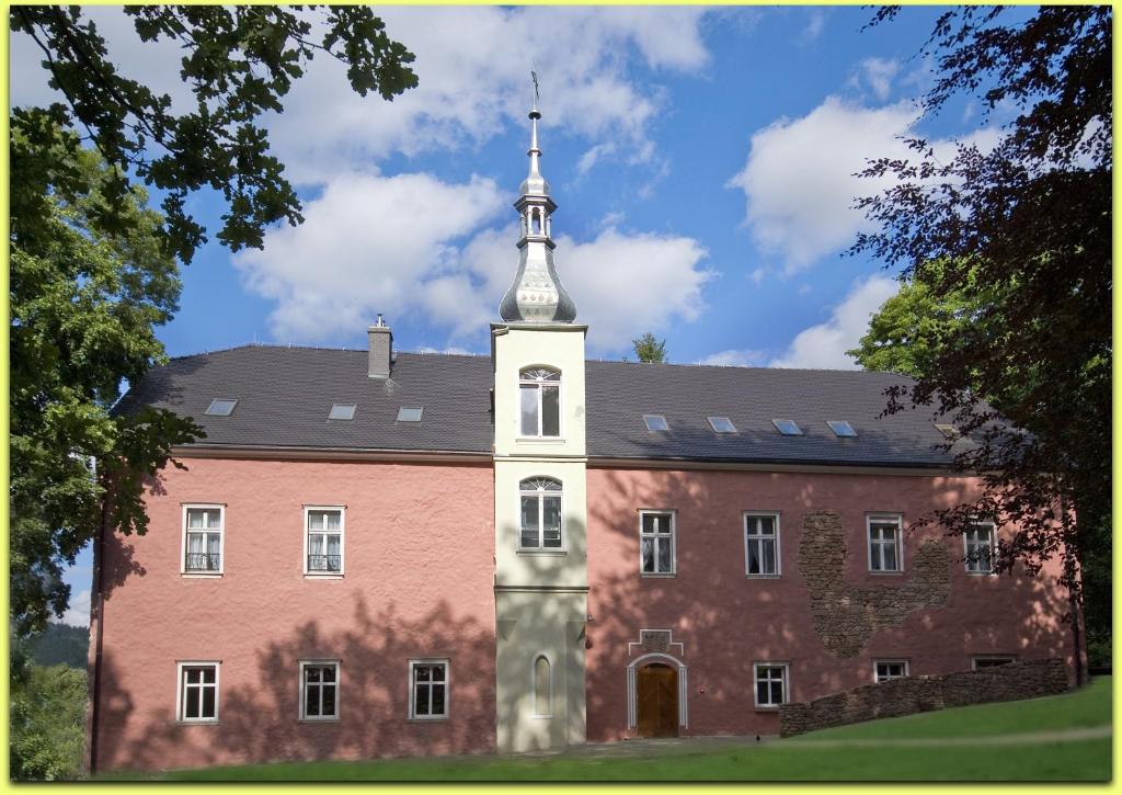 un gran edificio de ladrillo con una torre encima en Dwór Górny, en Nowa Ruda