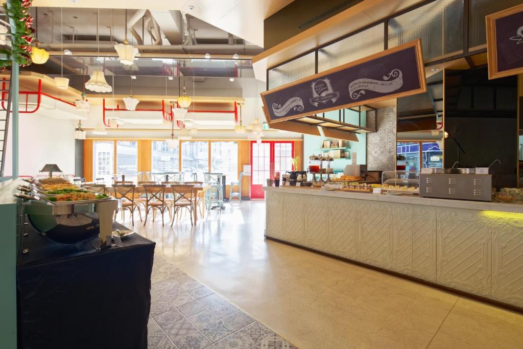 a restaurant with a counter and a table with chairs at Hotel 7 Taichung in Taichung