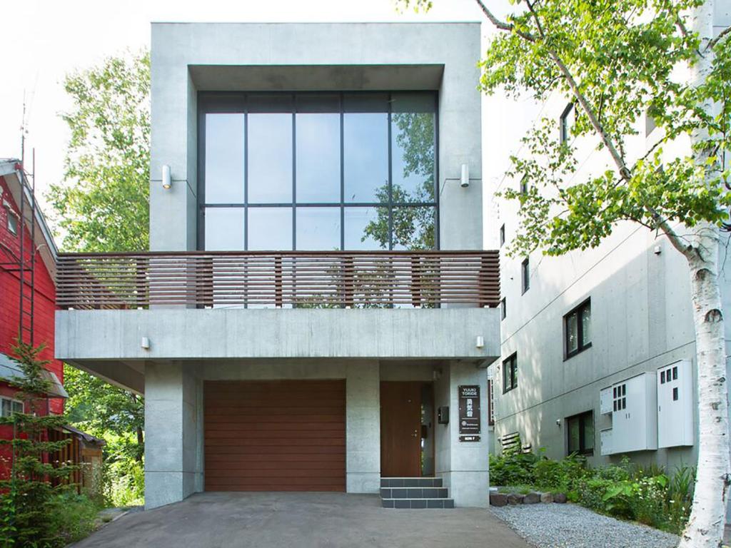 a building with a balcony on top of it at Yuuki Toride Chalet in Niseko