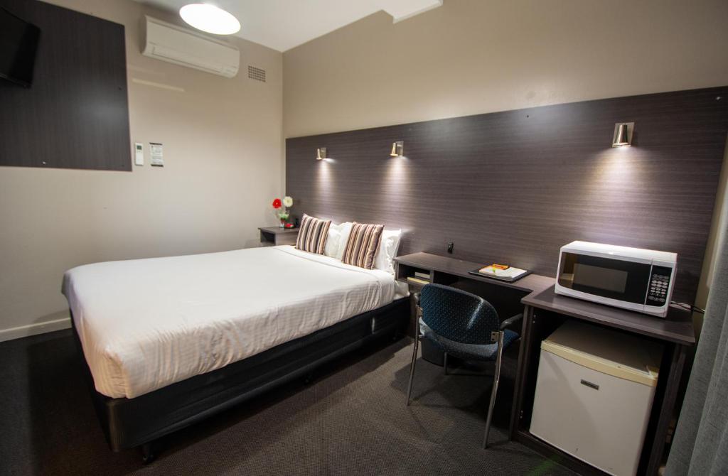 The Midcity Motor Lodge tesisinde bir odada yatak veya yataklar