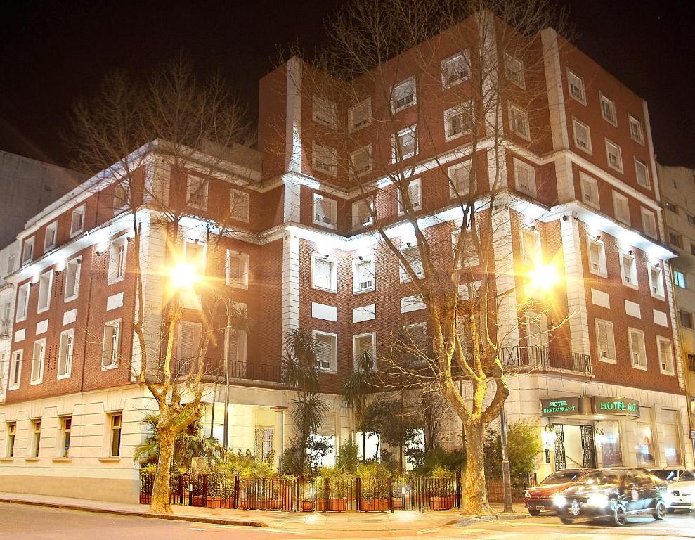 un gran edificio de ladrillo con luces encendidas por la noche en Garden Hotel en Mar del Plata