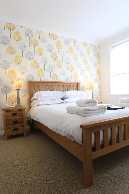 a bedroom with a bed with a yellow and gray wall at B+B York in York