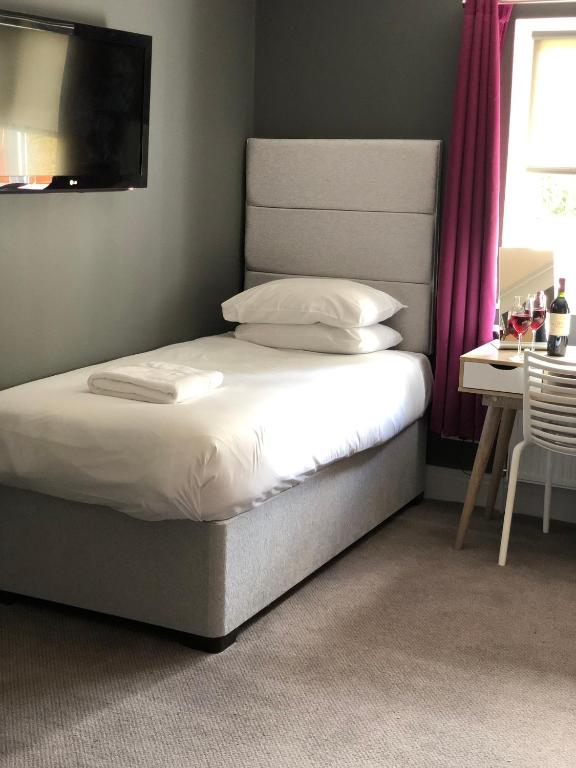 a bedroom with a bed and a table and a television at B+B York in York