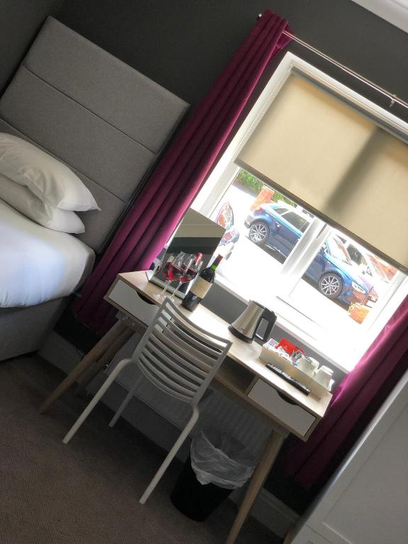 a bedroom with a desk and a bed and a window at B+B York in York