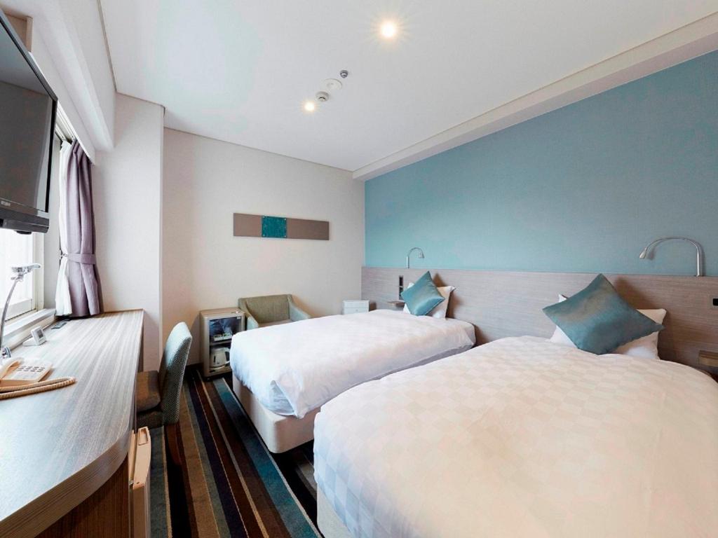 a hotel room with two beds and a television at Shinagawa Prince Hotel N Tower in Tokyo