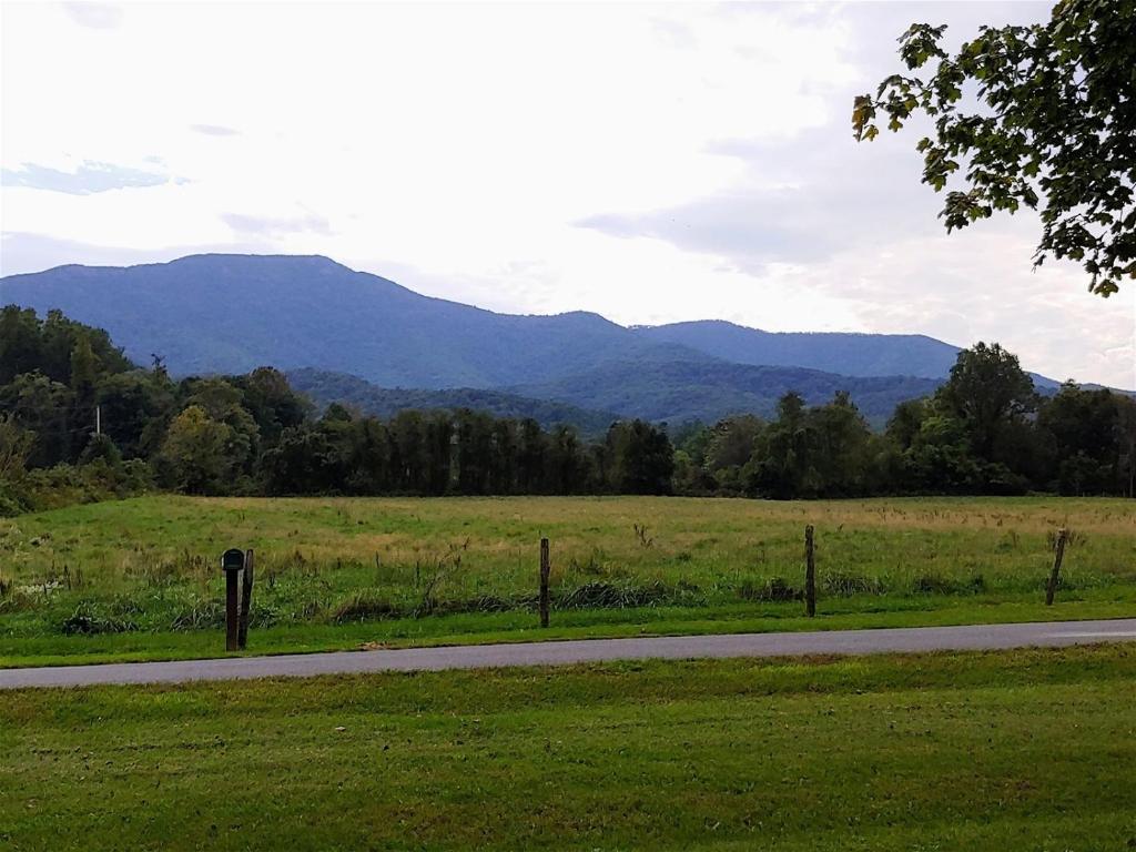a road in a field with mountains in the background at B And A Lake Cottage in Luray