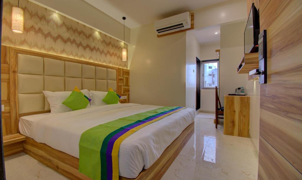 - une chambre avec un grand lit et une télévision dans l'établissement Hotel Amisha International, à Surate