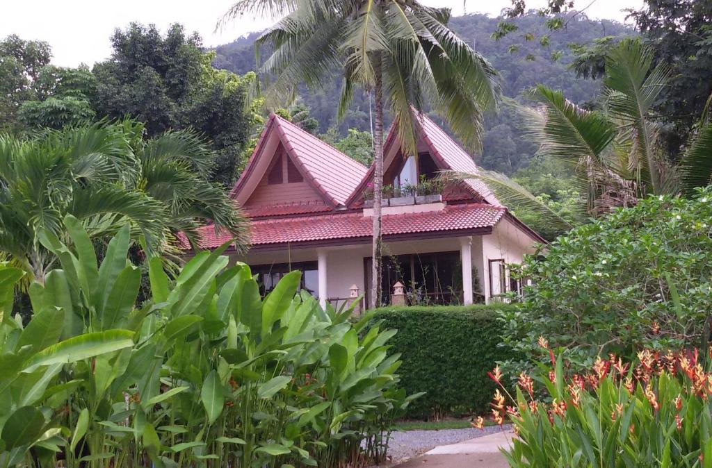 una casa con techo rojo en un jardín en Periwinkle Villa, en Ko Chang