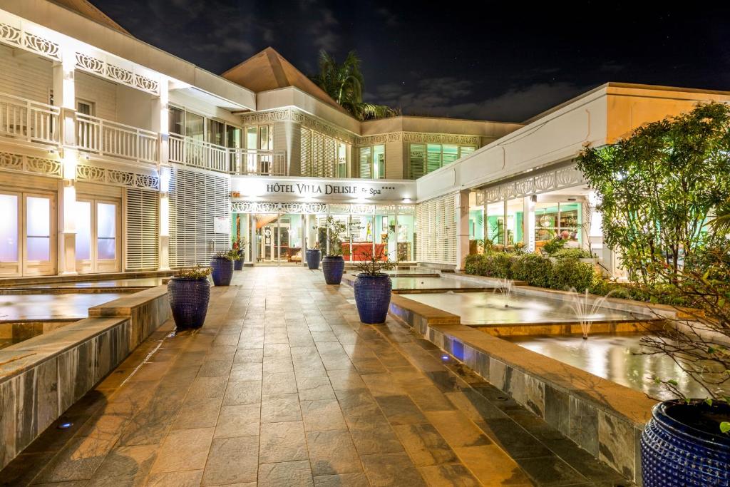 un edificio con bancos delante de él por la noche en Villa Delisle Hôtel & Spa en San Pedro