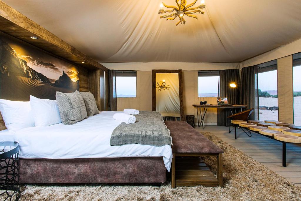 sypialnia z dużym łóżkiem w pokoju z oknami w obiekcie Dead Valley Lodge w mieście Sesriem