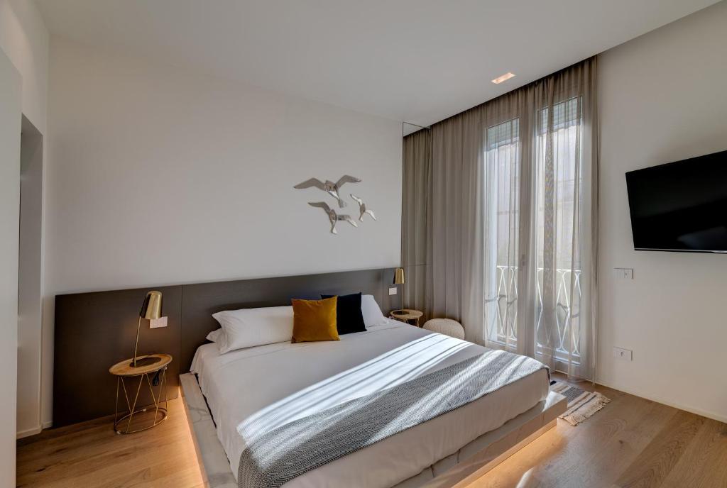 a bedroom with a large bed and a large window at Le Palmette Suites in Cagliari