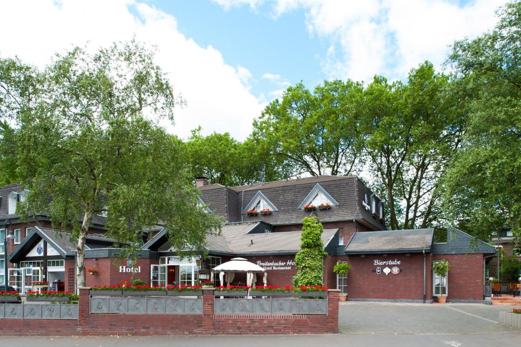 un restaurant avec un bâtiment en briques rouges dans l'établissement Hotel-Restaurant Breitenbacher Hof, à Hürth
