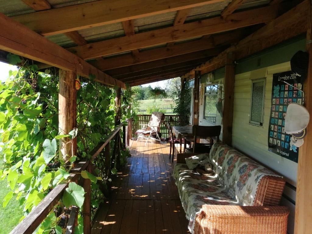 eine überdachte Veranda mit einem Sofa und einem Tisch in der Unterkunft Medumi Lake in Medumi